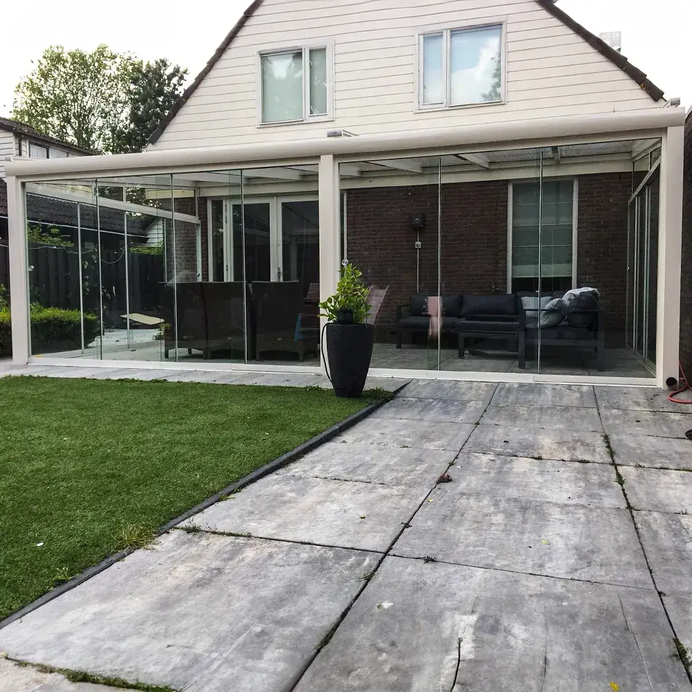 Crème-witte tuinkamer-overkapping met glazen schuifwanden aan alle zijden en zonwering bovenop