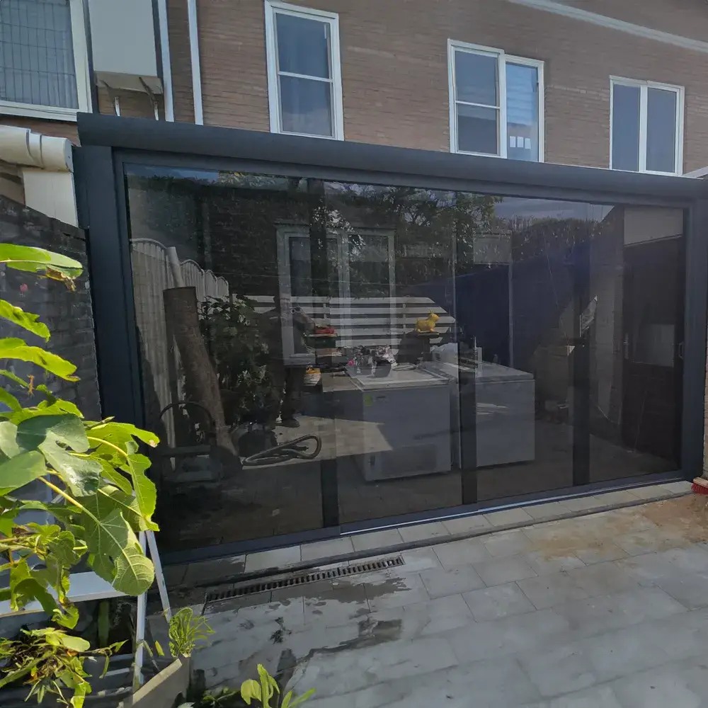 Gezin geniet van een middag onder een aluminium veranda met glazen dak.