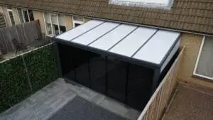 Polycarbonaat veranda in een moderne achtertuin met tuinmeubelen.